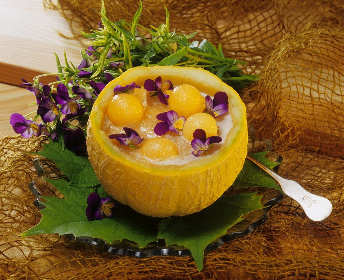 Cold melon soup with pansies in melon half