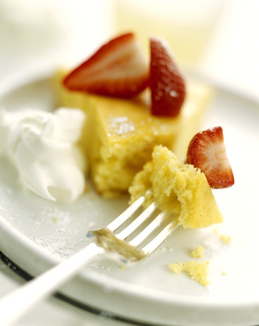 A piece of lemon cake with strawberries and cream