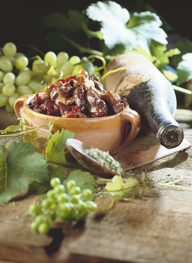 Eine Schale Cassoulet, daneben eine Flasche Wein