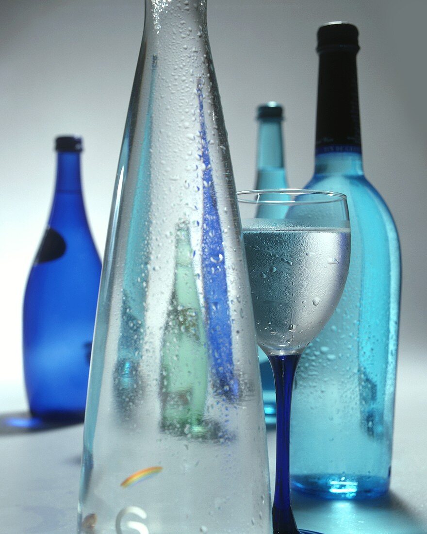 Mineral water in decorative bottles and in a glass