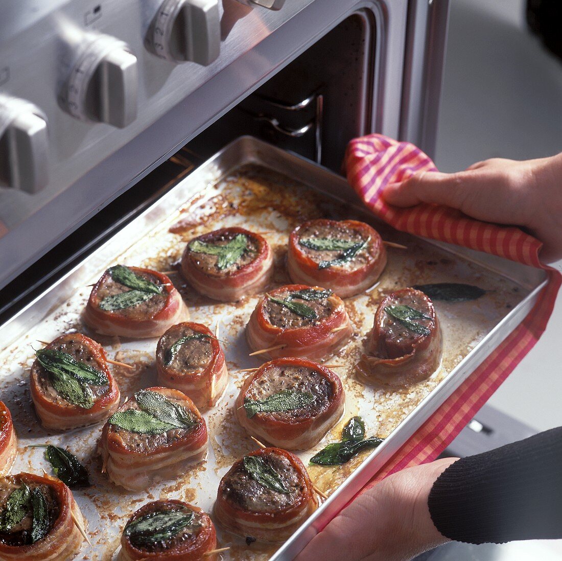 Taking saltimbocca style pork fillet out of the oven