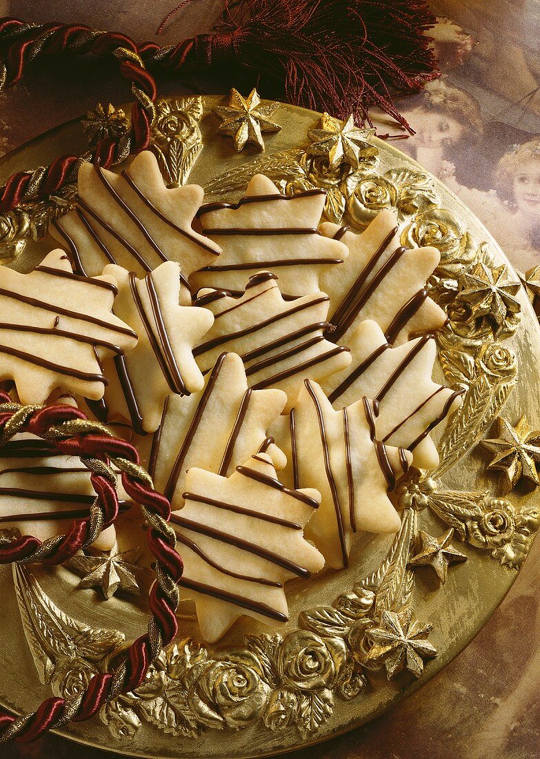 Biscuits decorated with chocolate lines on a golden plate