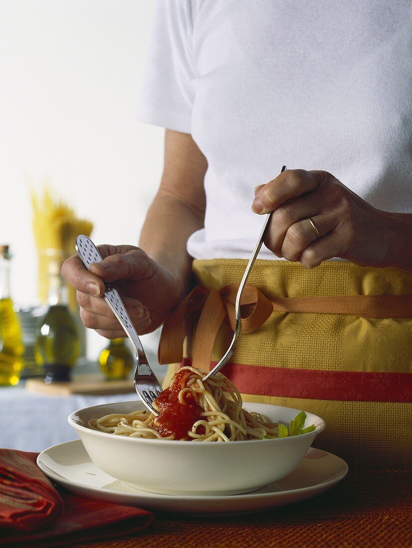 Spaghetti mit Tomatensauce vermischen