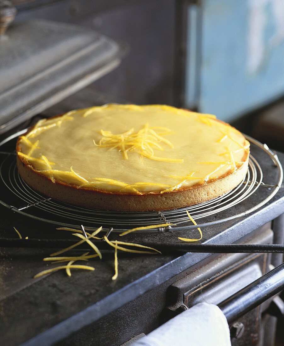 Lemon tart with lemon zest on cake rack