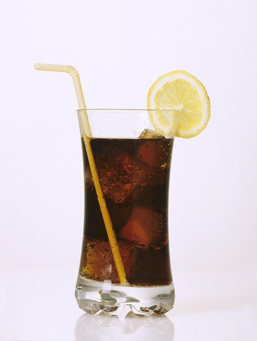 Ein Glas Cola mit Eiswürfeln, Zitronenscheibe und Strohhalm