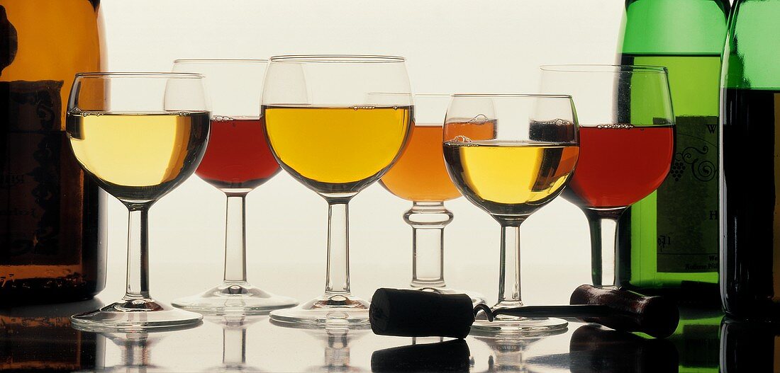 Weingläser mit Weißwein, Rotwein und Rose