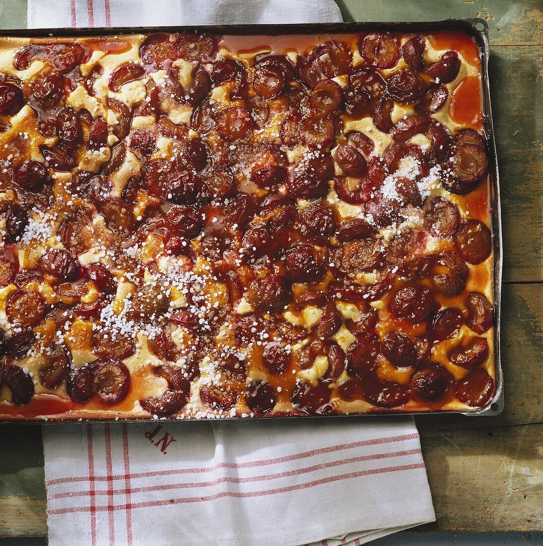 Plum cake with caramel icing on a baking tray