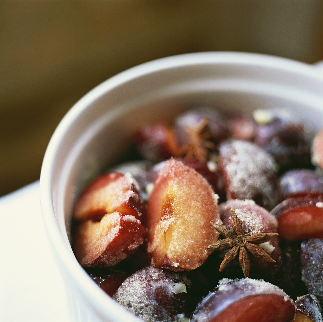Sugared damsons with star anise in a white dish