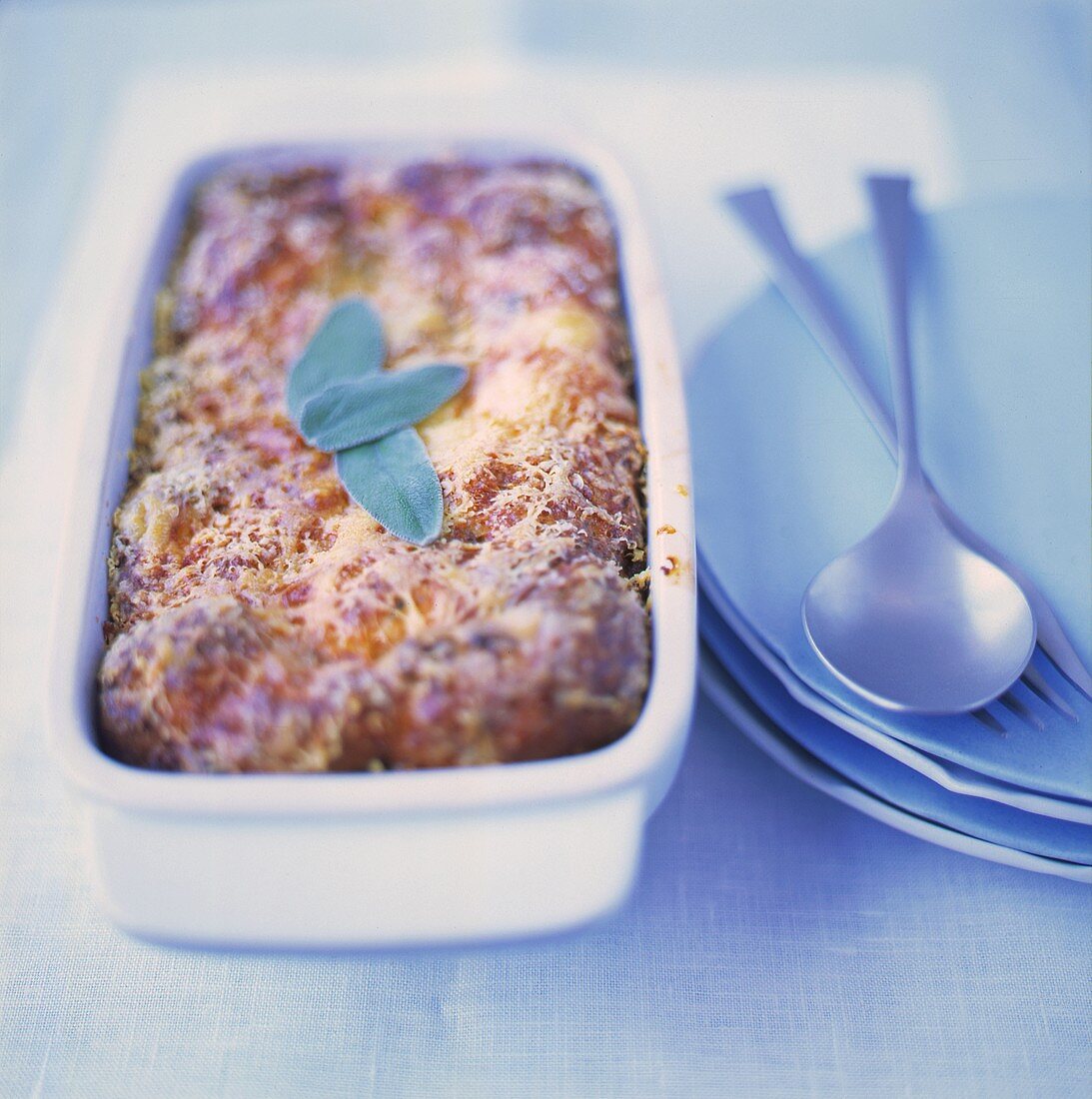 Bread pudding with sage leaves in a baking dish