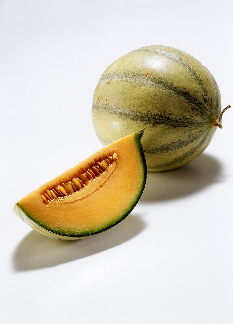 Eine ganze Charentais-Melone und ein Melonenschnitz