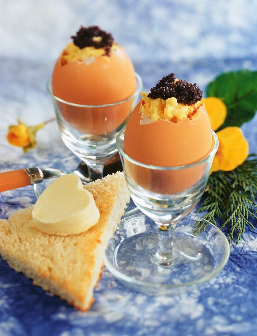 Scrambled egg with caviare in egg shell, with buttered toast