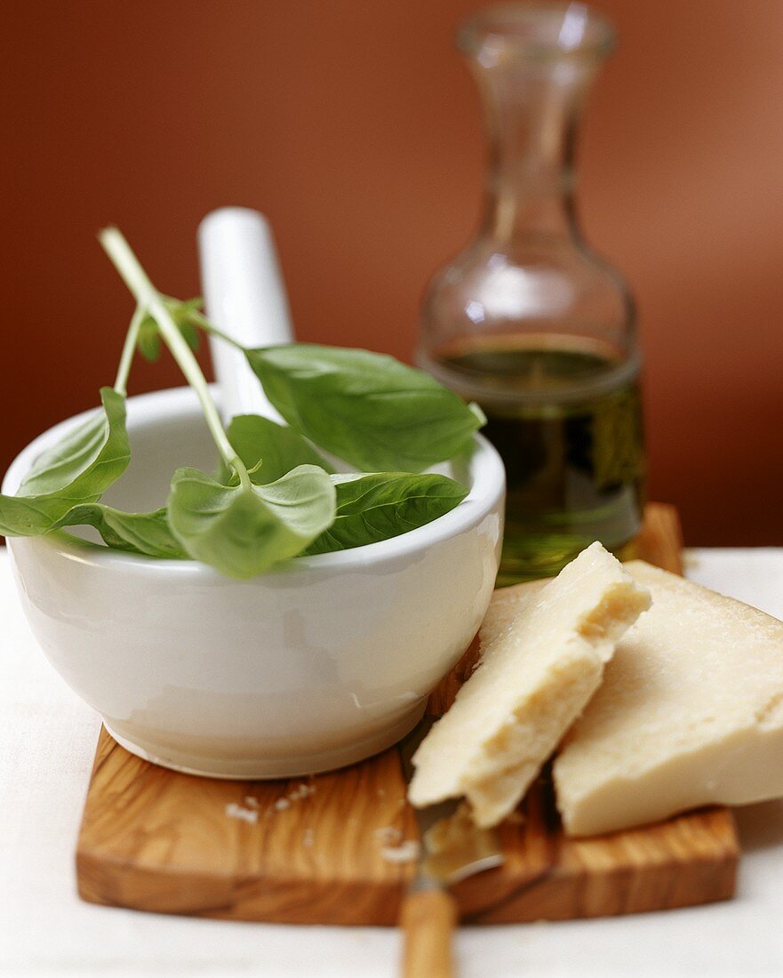 Stillleben mit Basilikum im Mörser, Parmesan und Olivenöl