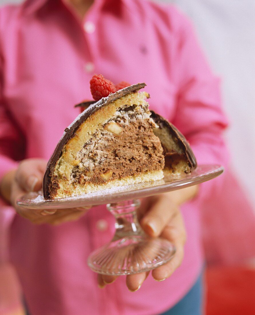 Frau serviert Zuccottotorte auf Kuchenplatte