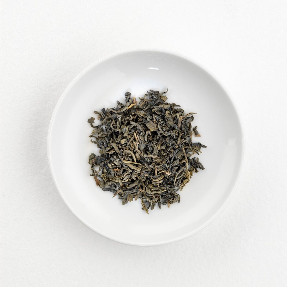 Grüne Teeblätter (Gu Zhang, China) auf Teller