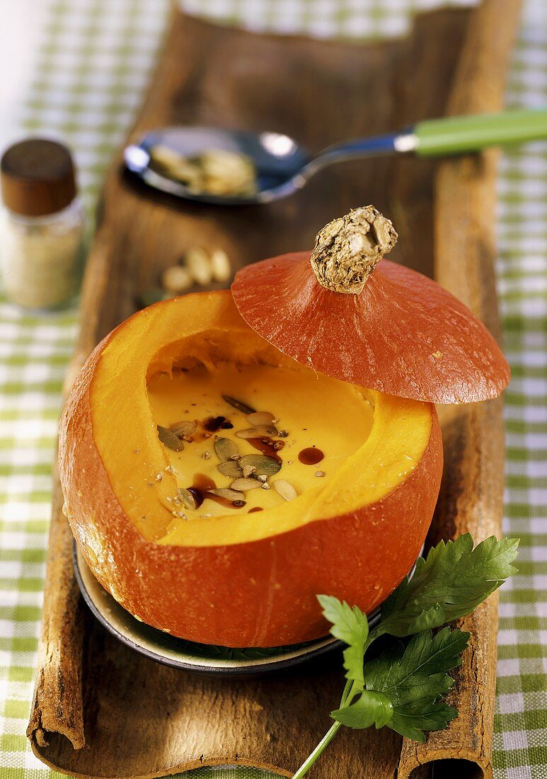 Creamed pumpkin soup with pumpkin seeds in hollowed-out pumpkin