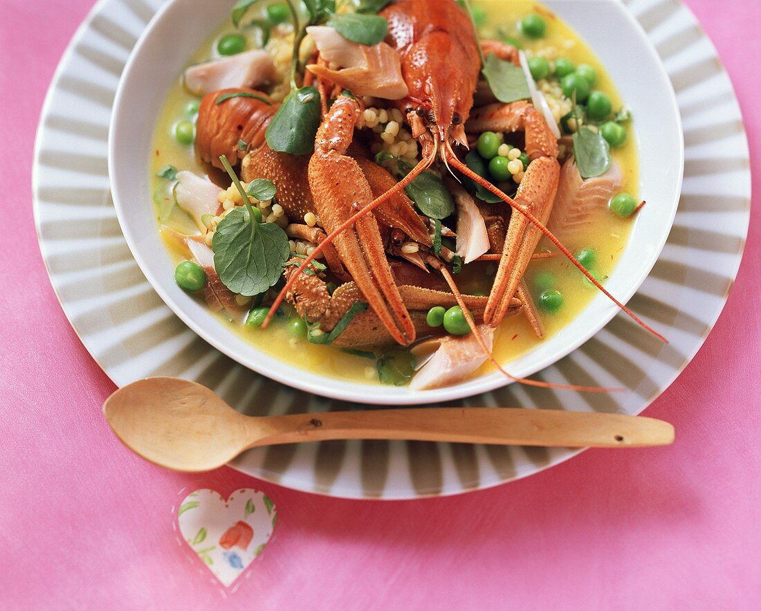 Freshwater crayfish, fish and pearl barley stew on plate