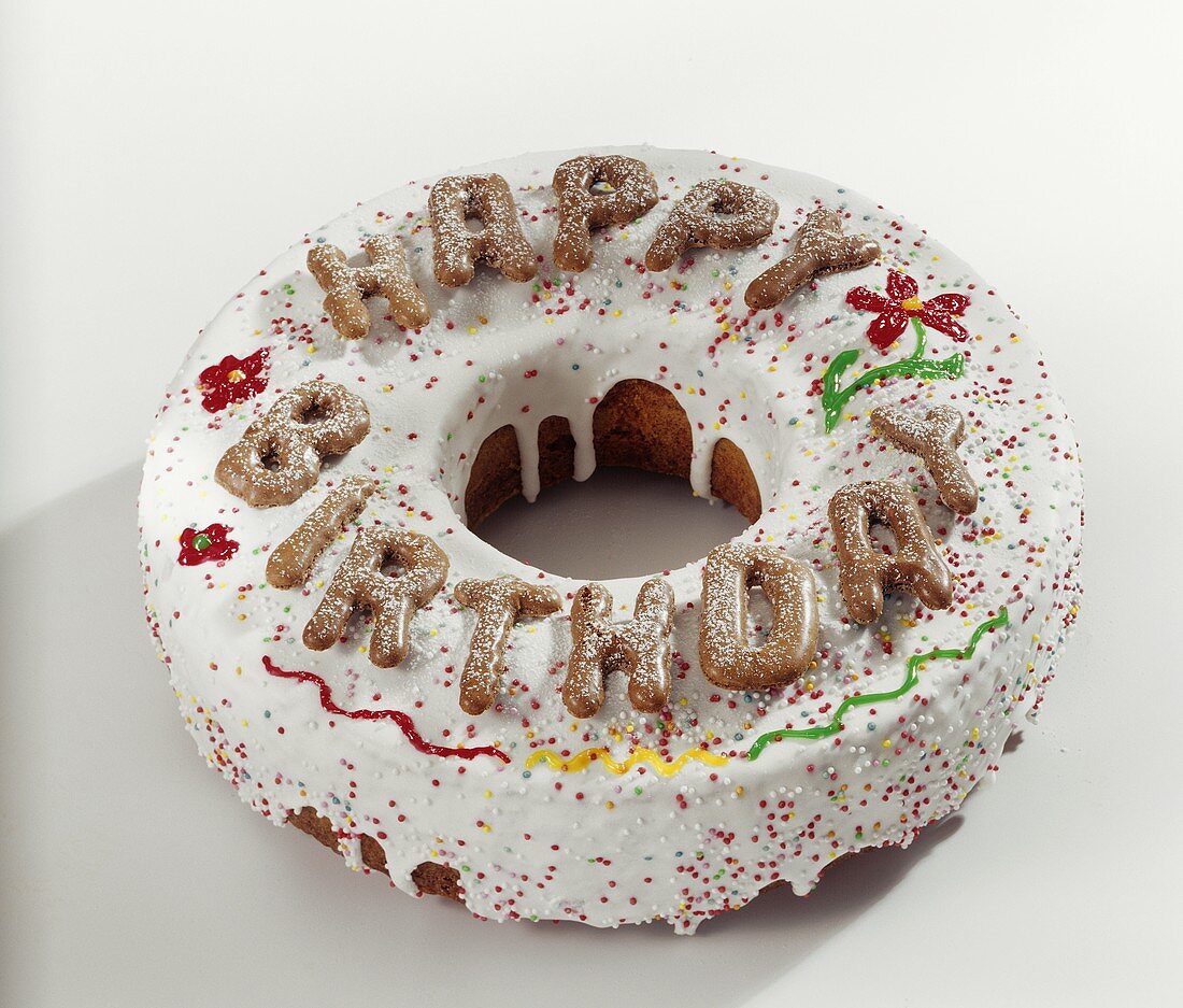 Kranzkuchen mit Zuckerglasur und Happy-Birthday-Buchstaben