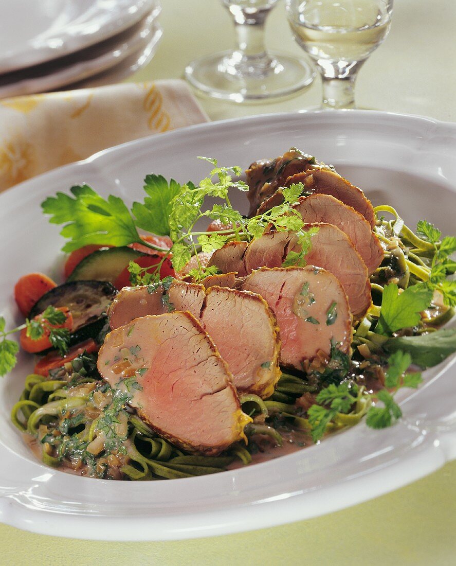 Pork fillet with herb and mustard sauce on ribbon pasta