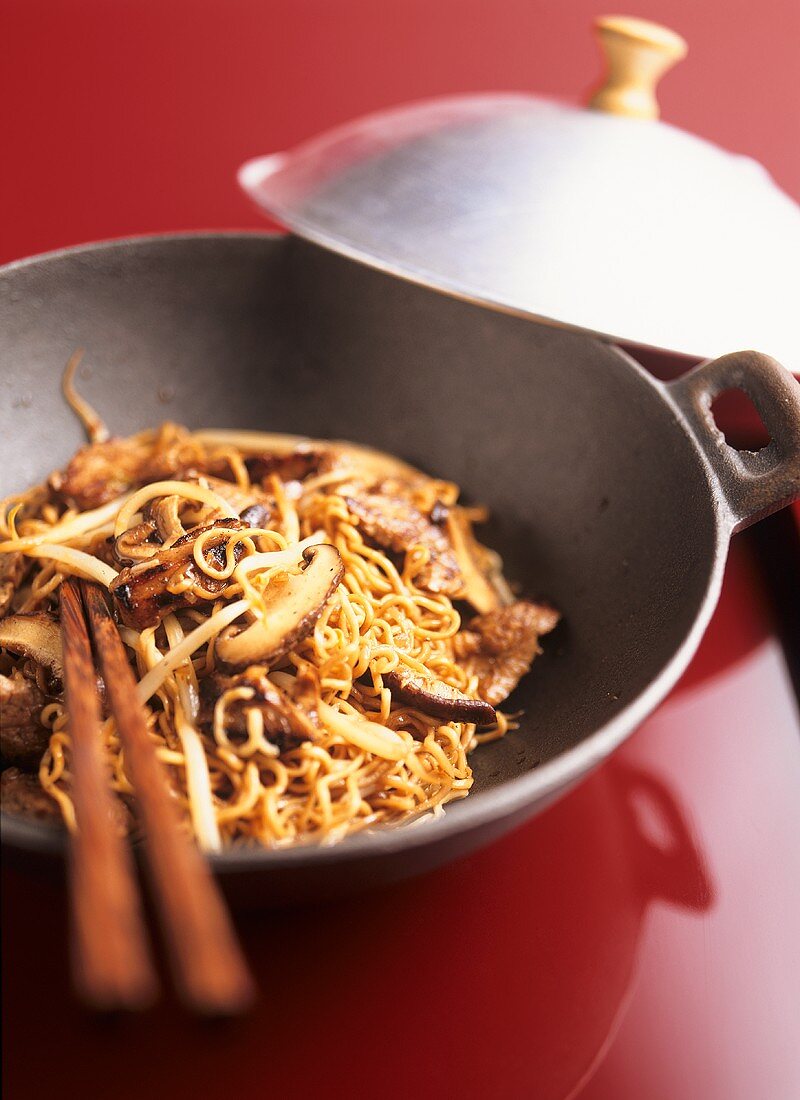 Noodles with pork fillet, sprouts and mushrooms in wok