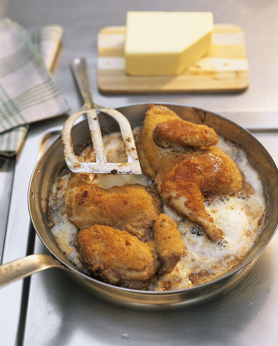 Frying breaded poussin in butter