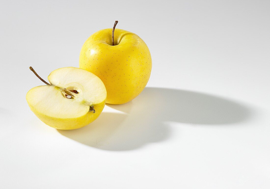 Ganzer und halber Apfel (Sorte Golden Delicious)