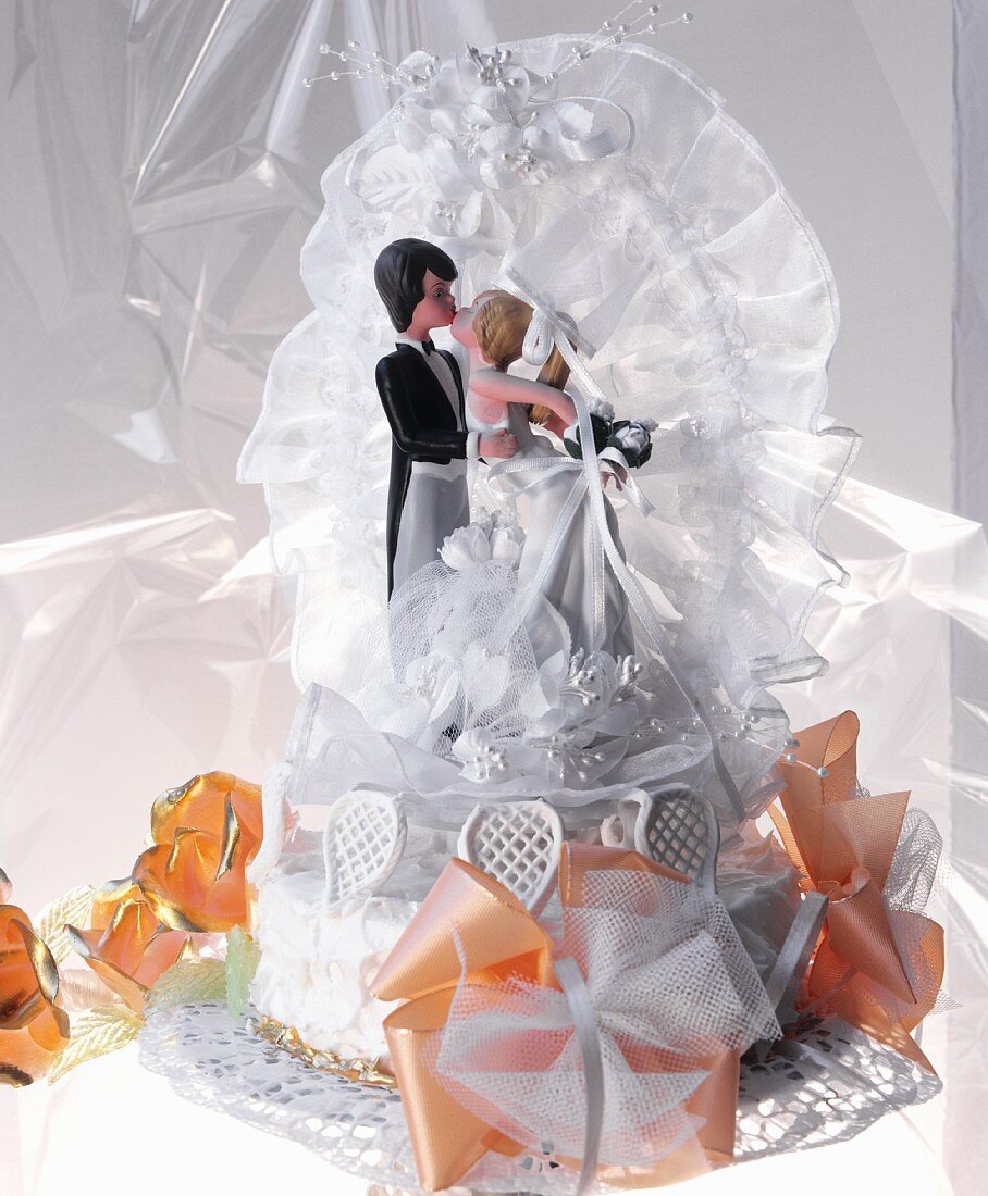 weiße Hochzeitstorte mit Brautpaarfiguren