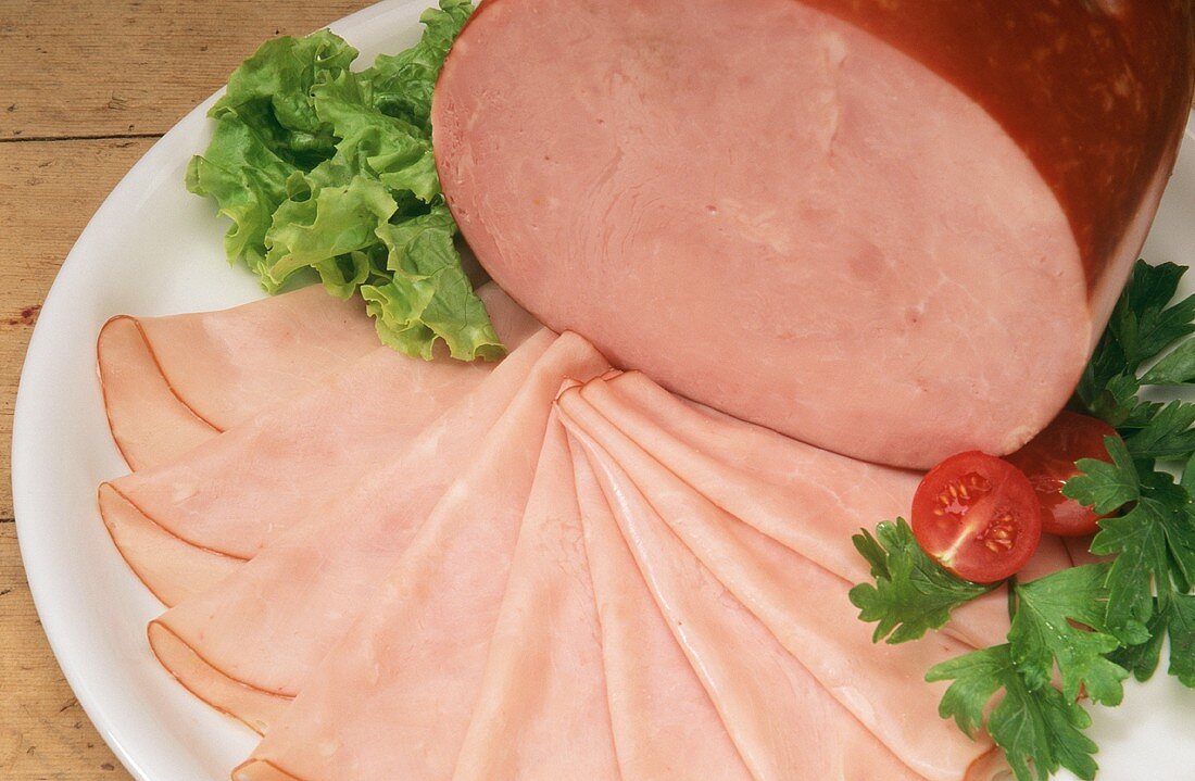 Boiled ham, carved and in the piece