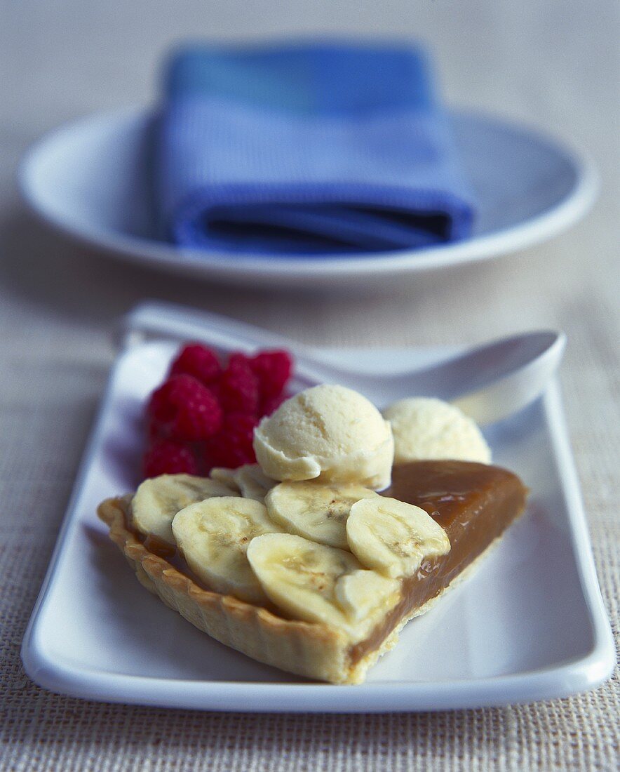 Banana and caramel tart with ice cream and raspberries