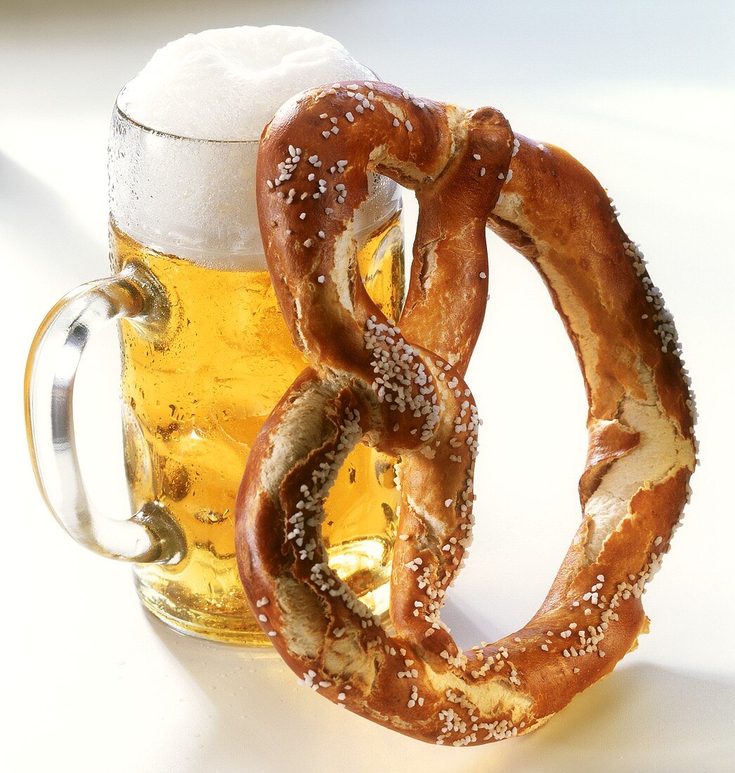 A salt pretzel beside a litre of beer