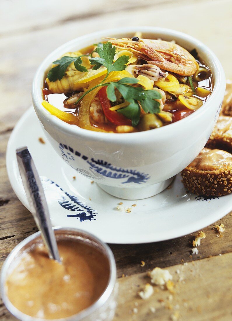 Fish soup with seafood, peppers and olives