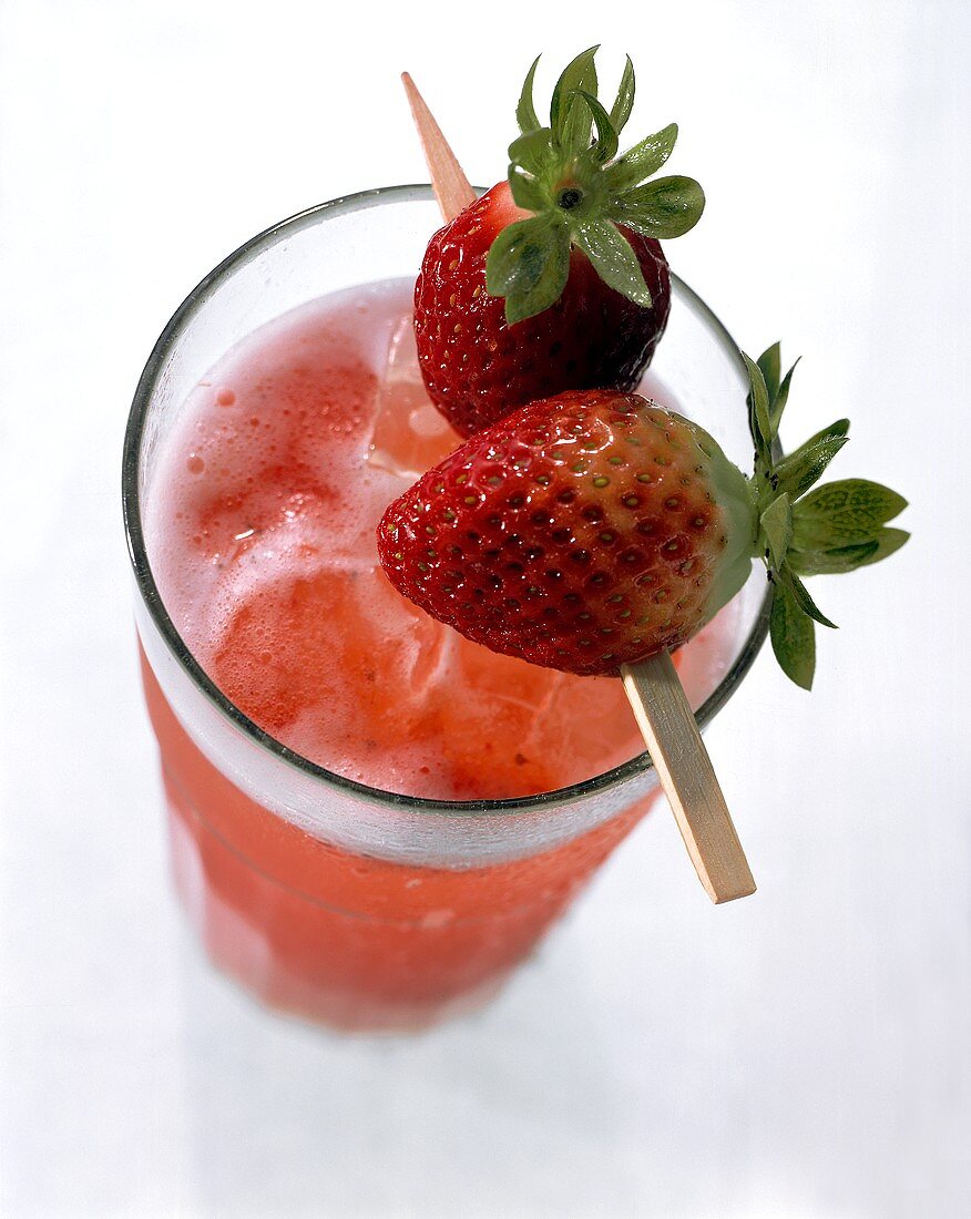 Strawberry drink with ice cubes garnished with strawberries