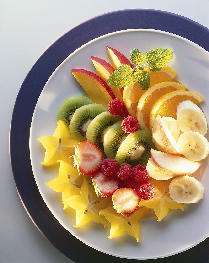 Slices of fruit and berries on plate