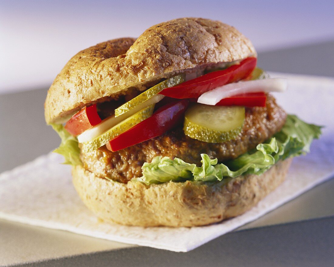 A hamburger with gherkin and peppers