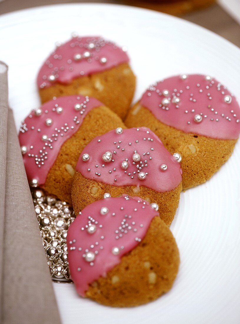 Plätzchen mit rosa Glasur und Zuckerperlen