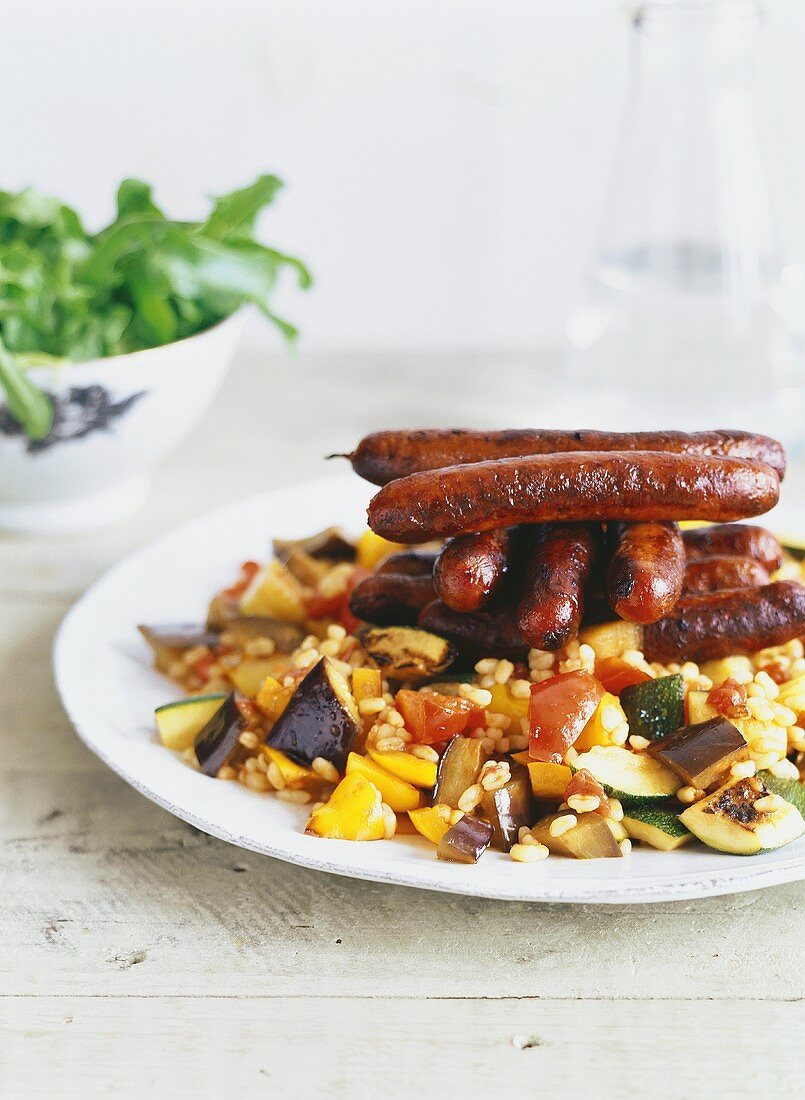 Barbecued sausages on vegetables with wheat