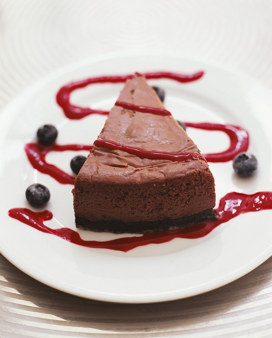 Piece of chocolate cake with blueberry sauce
