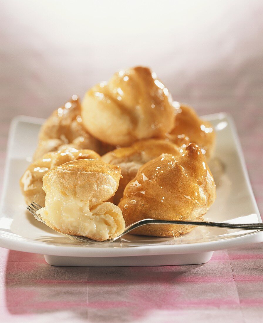 Profiteroles with cream filling, glazed with caramel