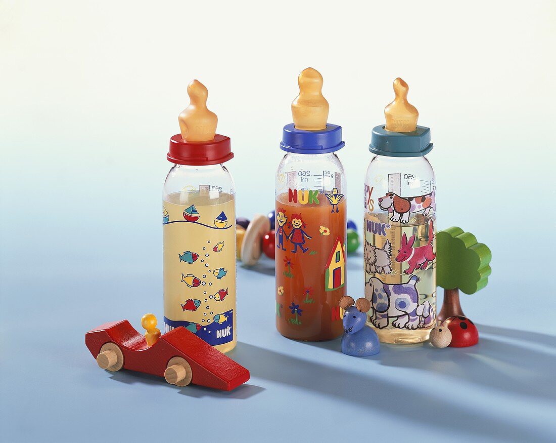 Three baby bottles with juices