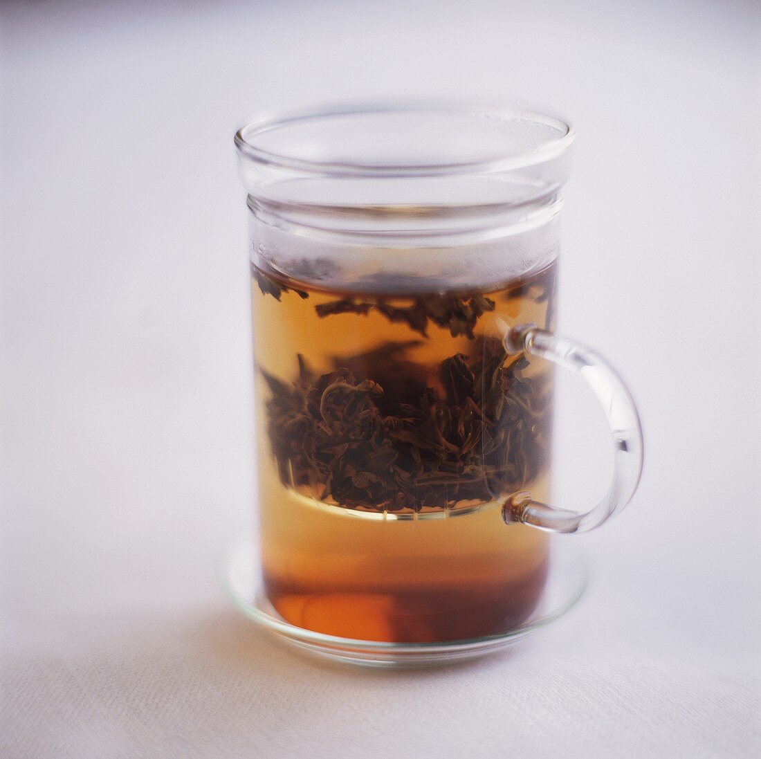Black tea with tea leaves in glass
