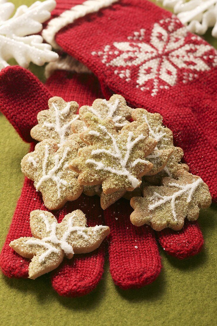 Christmas biscuits on red woollen gloves