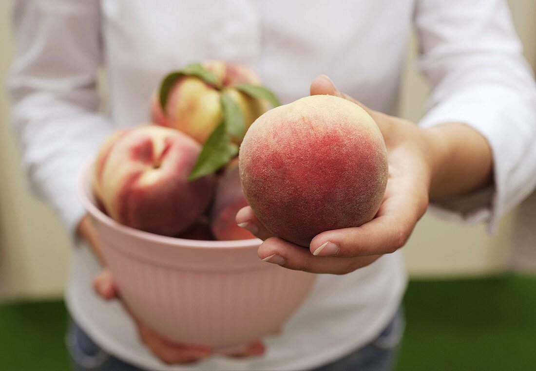 Woman holding fresh peaches