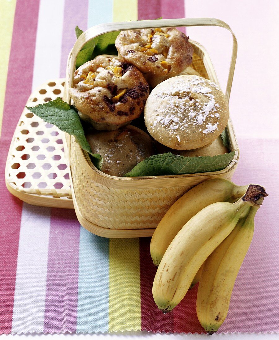 Banana muffins and chocolate & mango muffins in basket, bananas