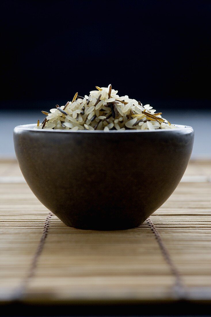 Long-grain rice with wild rice in brown bowl