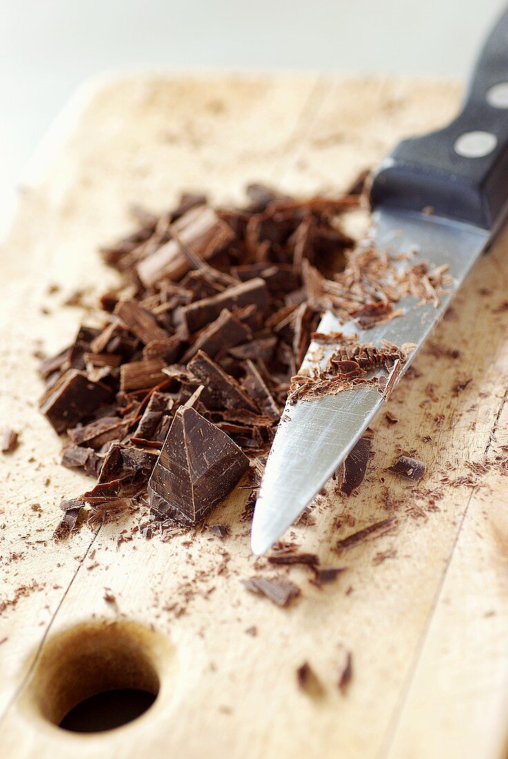 Chopped chocolate on chopping board with knife