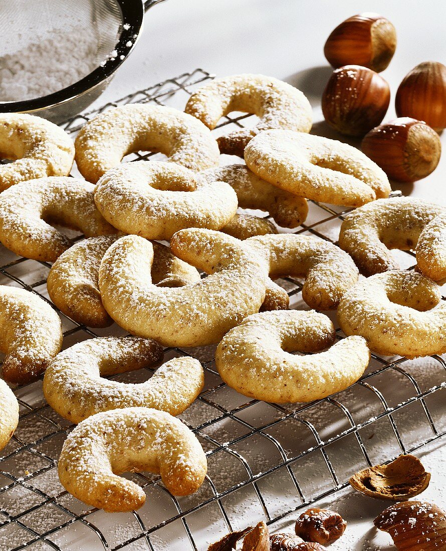Vanilla crescents with icing sugar on cake rack