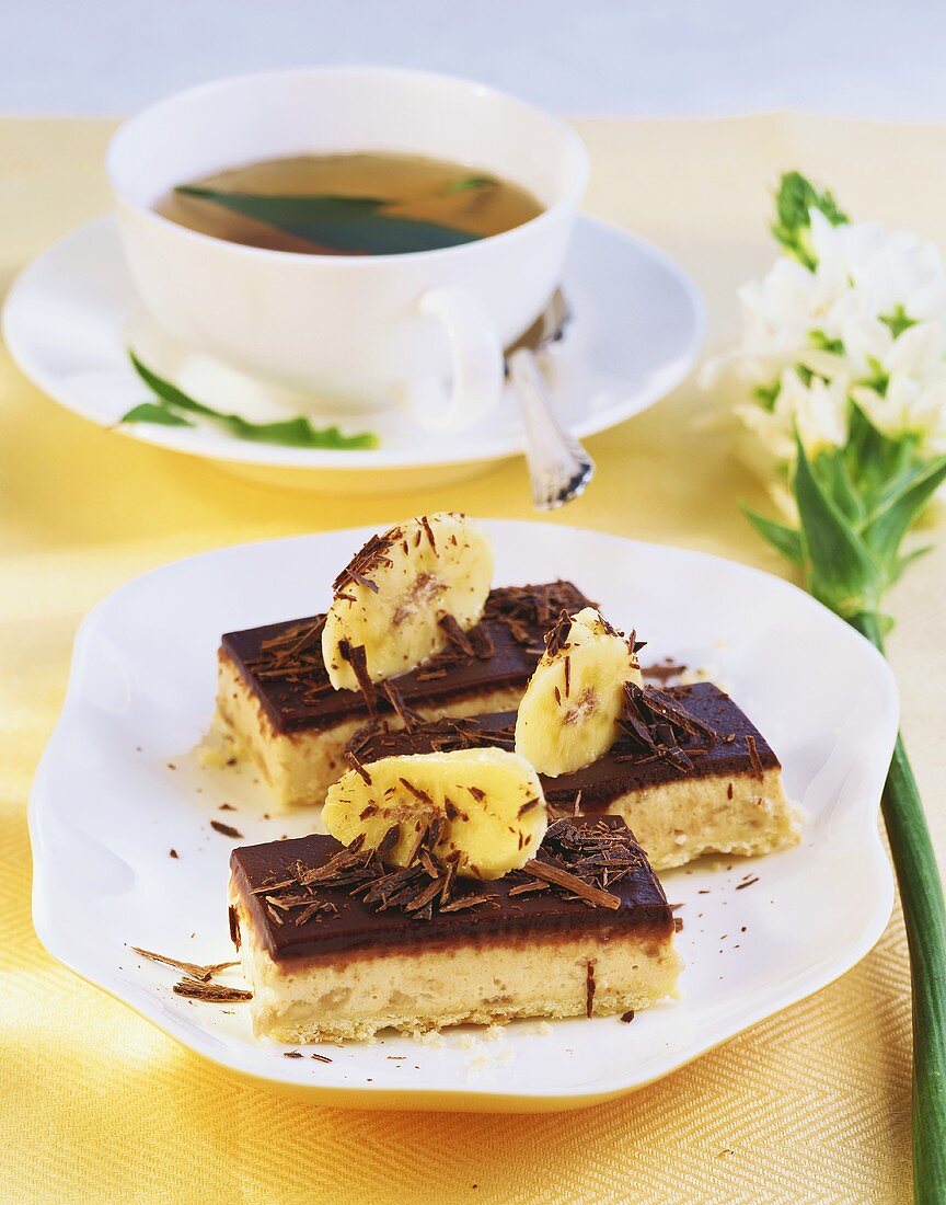 Banana slices with chocolate icing, cup of tea