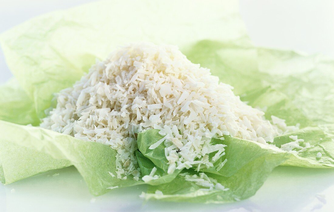 A heap of grated coconut on green paper