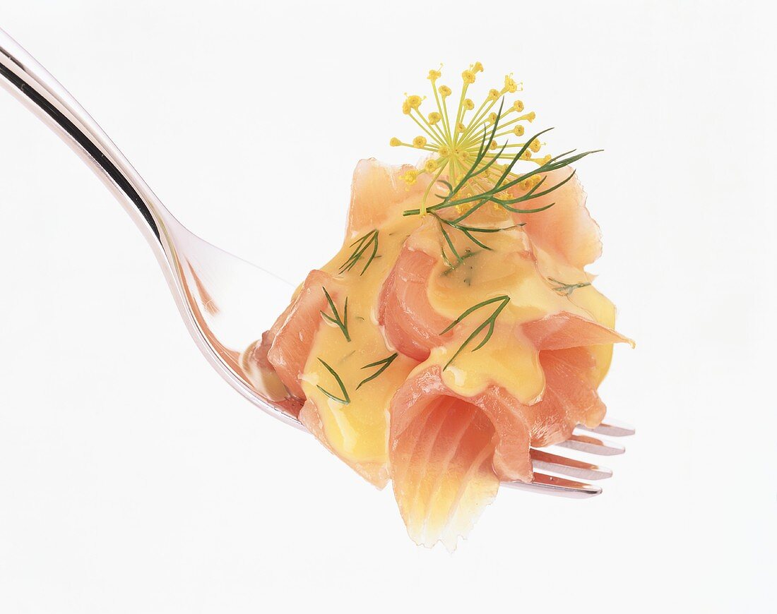 Smoked salmon with dill sauce on fork