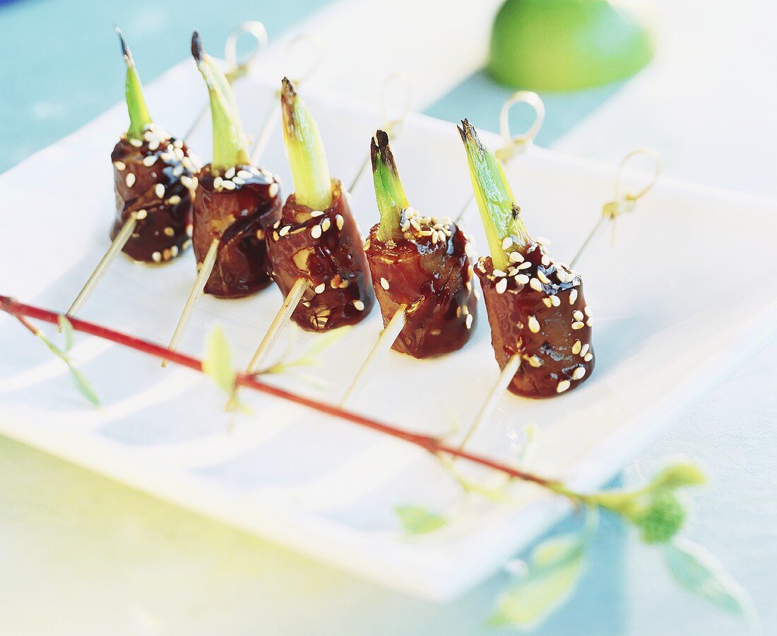 Skewered beef rolls with sesame and spring onions