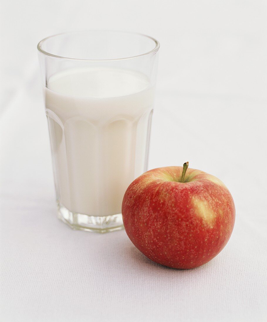 Glas Milch und roter Apfel